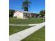 Corner view of a single-story home with a grassy lawn and a sidewalk at 8409 Trionfo Ave, North Port, FL 34287