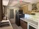 Functional kitchen with a black refrigerator, light wood cabinets, double sink, and white appliances at 8409 Trionfo Ave, North Port, FL 34287