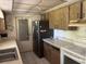 Compact kitchen featuring a stainless steel refrigerator and outdated wooden cabinetry at 8409 Trionfo Ave, North Port, FL 34287