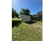 Metal shed in the backyard, with grassy area and wooden fence, under a sunny sky at 8409 Trionfo Ave, North Port, FL 34287