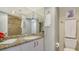 Bathroom with a tiled shower, granite counters and white cabinets at 1 Benjamin Franklin Dr # 93, Sarasota, FL 34236