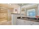 Updated bathroom featuring granite countertops, tiled shower, and large vanity mirror at 1 Benjamin Franklin Dr # 93, Sarasota, FL 34236
