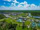 Expansive aerial view of a Primary-planned community showcasing pools, tennis courts, and green spaces for an active lifestyle at 10177 Crystal Isle Cir, Sarasota, FL 34241