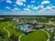 Aerial view of a vibrant community featuring pools, clubhouses, playgrounds, and tennis courts at 10177 Crystal Isle Cir, Sarasota, FL 34241