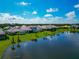 Beautiful lakefront homes showcasing lush landscaping, tile roofs, and serene water views under a bright, partly cloudy sky at 10177 Crystal Isle Cir, Sarasota, FL 34241