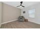 Cozy bedroom with comfortable chair, ceiling fan, and wood-look tile floor at 10177 Crystal Isle Cir, Sarasota, FL 34241