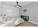 Well-lit bedroom with ceiling fan, sleek wood-look tile floor, and stylish decor at 10177 Crystal Isle Cir, Sarasota, FL 34241