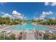 Beautiful community pool area with a gated entrance, lush landscaping, and comfortable lounge seating for relaxation at 10177 Crystal Isle Cir, Sarasota, FL 34241