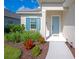 Attractive home entrance with blue door and shutters, lush landscaping, and a well-manicured lawn at 10177 Crystal Isle Cir, Sarasota, FL 34241