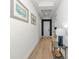 Inviting hallway with decorative light fixture, neutral paint, and wood-look tile flooring at 10177 Crystal Isle Cir, Sarasota, FL 34241