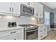 Modern kitchen features stainless appliances, white cabinets, and a tile backsplash at 10177 Crystal Isle Cir, Sarasota, FL 34241