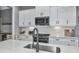 Close up of modern kitchen features white cabinets, tile backsplash, and stainless steel appliances at 10177 Crystal Isle Cir, Sarasota, FL 34241