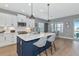 Well-lit kitchen with a blue island, quartz countertops, and modern appliances at 10177 Crystal Isle Cir, Sarasota, FL 34241
