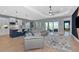 Open-concept living space with modern finishes, wood-look tile flooring, and sliding glass doors at 10177 Crystal Isle Cir, Sarasota, FL 34241