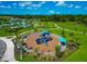 Aerial view of community playground with colorful equipment, seating, and nearby community pool and green spaces at 10177 Crystal Isle Cir, Sarasota, FL 34241