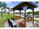 Community gathering spot with swings and benches, shaded by a pavilion and framed by palm trees at 10315 Cortez W Rd # 60-4, Bradenton, FL 34210