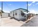 Well-maintained mobile home with a white exterior, teal awning, and convenient parking area at 10315 Cortez W Rd # 60-4, Bradenton, FL 34210