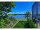 This house has a backyard with a serene lake view, framed by lush greenery and blue skies at 10571 Old Grove Cir, Bradenton, FL 34212