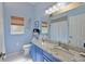 Blue bathroom features granite countertops, ample storage, and modern fixtures for a clean, refreshing feel at 10571 Old Grove Cir, Bradenton, FL 34212
