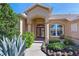 Inviting home entrance with decorative glass doors, manicured landscaping and a charming fountain at 10571 Old Grove Cir, Bradenton, FL 34212