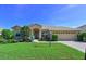 Charming single-story home featuring a well-manicured lawn, arched entryway and a two-car garage at 10571 Old Grove Cir, Bradenton, FL 34212