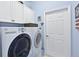 Bright laundry room with full-size washer, dryer, white cabinets, and a door to the side yard at 10571 Old Grove Cir, Bradenton, FL 34212