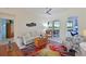 Bright living room features a colorful rug, comfortable seating, and sliding doors to a screened patio with a lake view at 10571 Old Grove Cir, Bradenton, FL 34212