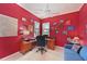 Office space with red walls, desk, chair, and comfortable seating, perfect for a home office at 10571 Old Grove Cir, Bradenton, FL 34212