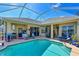 Inviting pool with a screened-in lanai, complemented by an outdoor kitchen and cozy seating areas at 10571 Old Grove Cir, Bradenton, FL 34212