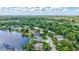 Overhead perspective of a community surrounded by lush greenery and a sparkling lake at 11250 Rivers Bluff Cir, Lakewood Ranch, FL 34202