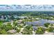 Expansive aerial shot of houses nestled in a lush, green neighborhood near tranquil lake waters at 11250 Rivers Bluff Cir, Lakewood Ranch, FL 34202