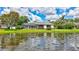Scenic backyard view of a well-maintained lawn, screened-in lanai, and a tranquil lake at 11250 Rivers Bluff Cir, Lakewood Ranch, FL 34202
