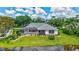 Waterfront property featuring a screened-in pool, lush landscaping, and beautiful lake views at 11250 Rivers Bluff Cir, Lakewood Ranch, FL 34202