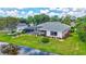 Lakeside backyard with a screened-in pool, lush landscaping, and picturesque water views at 11250 Rivers Bluff Cir, Lakewood Ranch, FL 34202