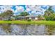 Waterfront backyard featuring a screened-in lanai, manicured lawn, and beautiful lake views at 11250 Rivers Bluff Cir, Lakewood Ranch, FL 34202