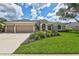 Beautiful single-story home with a three-car garage, manicured lawn, and colorful landscaping at 11250 Rivers Bluff Cir, Lakewood Ranch, FL 34202
