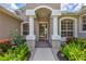Charming front entrance with decorative columns, a glass front door, and vibrant landscaping at 11250 Rivers Bluff Cir, Lakewood Ranch, FL 34202