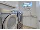 Laundry room equipped with modern washer and dryer, sink, and ample cabinet space at 11250 Rivers Bluff Cir, Lakewood Ranch, FL 34202