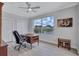 Bright office space includes a wood desk, scenic pond view, and wood-look tile floor at 11250 Rivers Bluff Cir, Lakewood Ranch, FL 34202