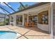Covered patio with brick pavers, outdoor dining area, and views of the pool and lake at 11250 Rivers Bluff Cir, Lakewood Ranch, FL 34202