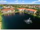 Aerial view of community with a lake and multiple buildings with red roofs at 150 L Pavia Blvd # 13, Venice, FL 34292