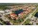 Expansive aerial view of the community, lake, and commercial areas surrounded by lush greenery at 150 L Pavia Blvd # 13, Venice, FL 34292
