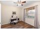 A bedroom featuring a window with blinds, wood floors, and desk with chair at 150 L Pavia Blvd # 13, Venice, FL 34292