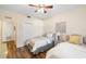Bright bedroom with twin beds, ceiling fan, wood floors, and light neutral walls at 150 L Pavia Blvd # 13, Venice, FL 34292