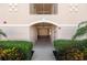 Building entrance showcasing arched doorway, shrubbery and a concrete path at 150 L Pavia Blvd # 13, Venice, FL 34292