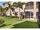 Back exterior of home with mature manicured landscaping and a screened in lanai at 150 L Pavia Blvd # 13, Venice, FL 34292