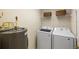 Bright laundry room with washer, dryer, storage shelves, and water heater at 150 L Pavia Blvd # 13, Venice, FL 34292