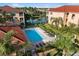 Aerial view of the community pool surrounded by lounge chairs, greenery, and palm trees at 150 L Pavia Blvd # 13, Venice, FL 34292