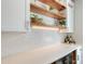 Stylish bar area features floating wood shelves, subway tile backsplash and beverage cooler at 1738 Siesta Dr, Sarasota, FL 34239