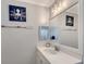 Coastal bathroom features a white vanity and sink, complemented by nautical-themed decorations and a bright mirror at 1738 Siesta Dr, Sarasota, FL 34239